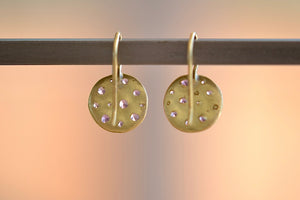 Polly Wales Celeste Node Hook Earrings in Lilac Simple ear wires in 18k gold with an attached disc, speckled with lilac to lavender sapphires around the circumference for a beautiful confetti-like appearance. Recycled gold. Cast not set.