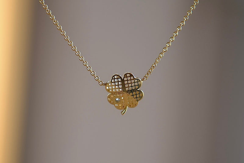 Retrouvai Petite Waffle Clover Leaf Pendant A unique modern take on an heirloom pendant. From their talisman collection, a perfectly shaped clover leaf with waffle texture in gold, accented with one white diamond hangs on a 16" 14k yellow gold chain.