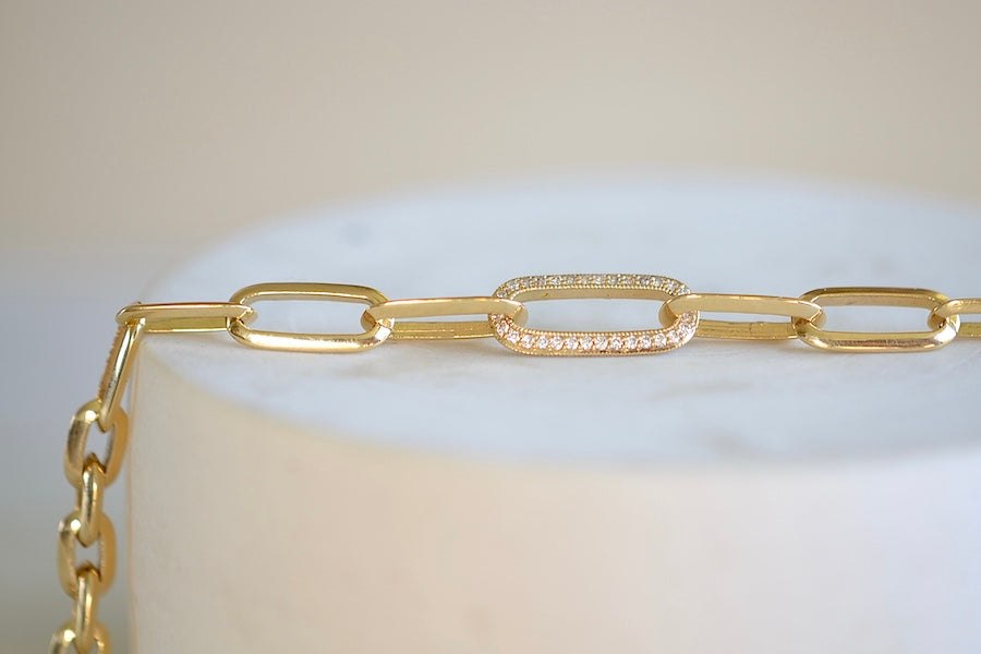 Knife Edge Oval Link Chain Bracelet with Single Pave Link by Lizzie Mandler is a clip bracelet with toggle closure and one pave adorned clip in Othello aka black diamonds on one side and white on the other in 18k yellow gold.