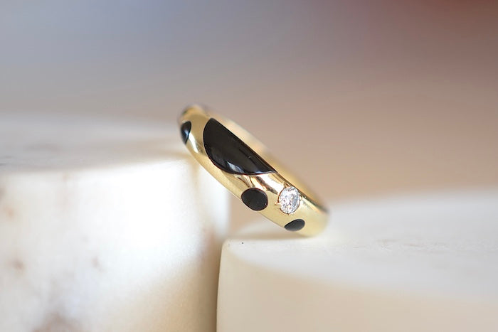 Retrouvai Petite Black Onyx Polka Bombe Ring is a  round 14k yellow gold ring made with stone inlay and one round brilliant cut accent diamond (.1CT) with a tapered band that has detailed edging available at OK. Modern and fun. Handmade is Los Angeles. 