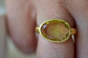 Lemon Quartz Large Greek Ring designed by Pippa Small is an organically shaped light yellow, faceted and transparent lemon quartz set in 18k yellow gold. On a ring finger 