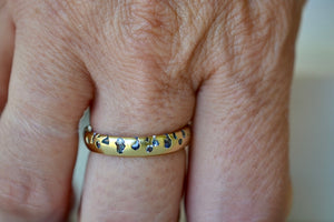 
            
                Load image into Gallery viewer, The Cornflower Blue Sapphire Confetti Band designed by Polly Wales is a narrow 18k yellow recycled gold wedding band/ring with speckled ombre light blue sapphires around the circumference. It is cast not set and handmade in Los Angeles.
            
        
