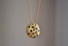 Polly Wales Spinning Disc Pendant Necklace in 18K yellow gold with scattered rainbow sapphires in orange, yellow, pink, blue, purple and lilac hangs on a beautiful chain 22" cast in place and cast not set in recycled gold.