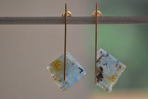One of a kind asymmetrical aquamarine stone earrings stones with natural inclusions attached to Kathleen Whitaker's signature elongated gold plate studs with post closure. Stone Collection.