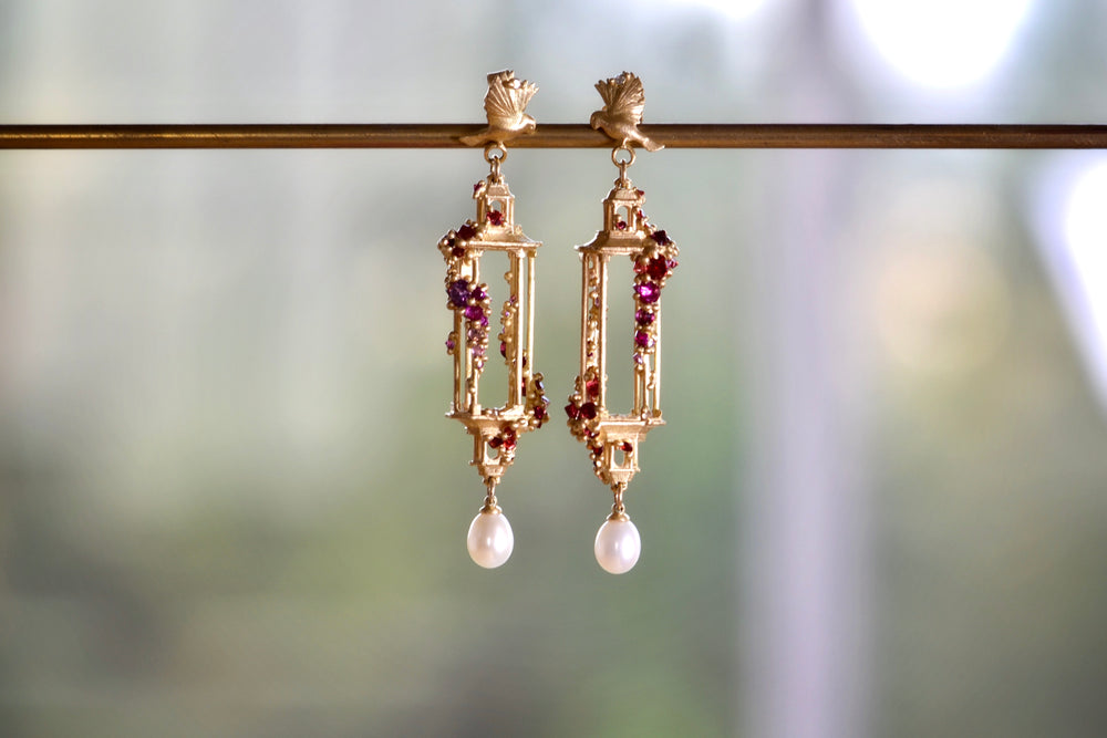 Polly Wales Jade Terrace Pagoda Earrings 18K yellow recycled gold pagoda forms hanging from a bird stud encrusted with a pearl pink sapphire sapphires. Cast not set.