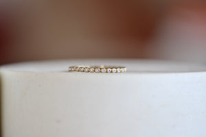 1mm thick porch band by Marian Maurer is a wedding band in bezel set round diamonds that is 1mm tall.