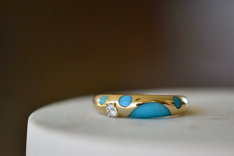 Petite Turquoise Polka Bombe Ring by Retrouvai is a round 14k yellow gold ring made with stone inlay and one round brilliant cut accent diamond (.1CT) with a tapered band that has detailed edging available at OK. Modern and fun.