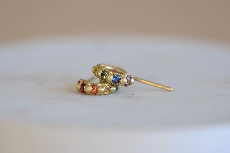 
            
                Load image into Gallery viewer, Polly Wales Rapunzel Ear Cuffs huggie buggies 18k yellow recycled gold pink, red, orange, yellow purple, blue and green sapphires and a matte finish. Cast not set.
            
        