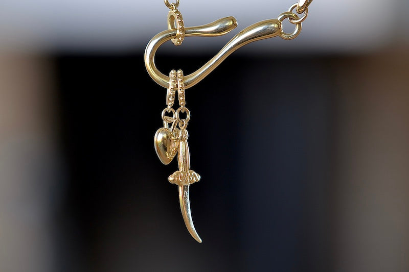Meredith Kahn Heart and dagger Charm with loop ring in brass on a hook and loop cable chain necklace..