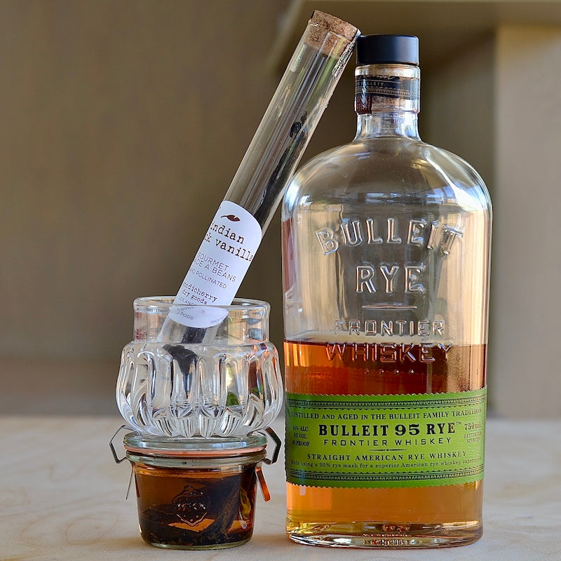 Indian Black Vanilla Pods in Vial next to sipper and bourbon for infusion.